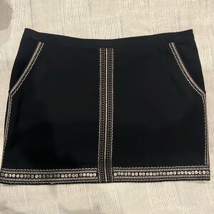 Black with gold detailing mini skirt. 15 1/2 inches in length. Back zipper.